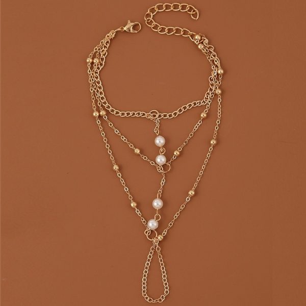 Bracelet bague avec chaînes dorés et perles blanches