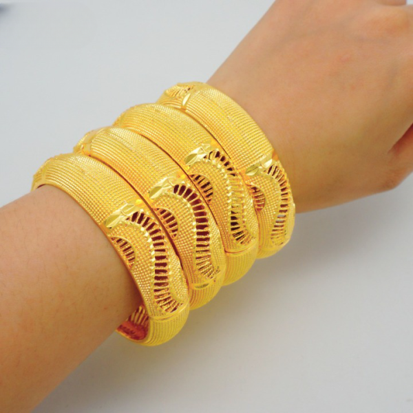 4 bracelets doré style africain autour d'un poignet
