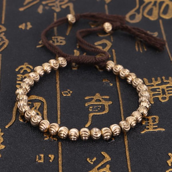 Bracelet bouddhiste tibétain en fil de coton tressé et perles de laiton