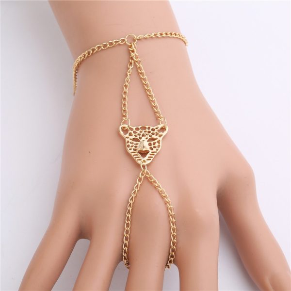 Bracelet bague doré porté par la main d'une femme.