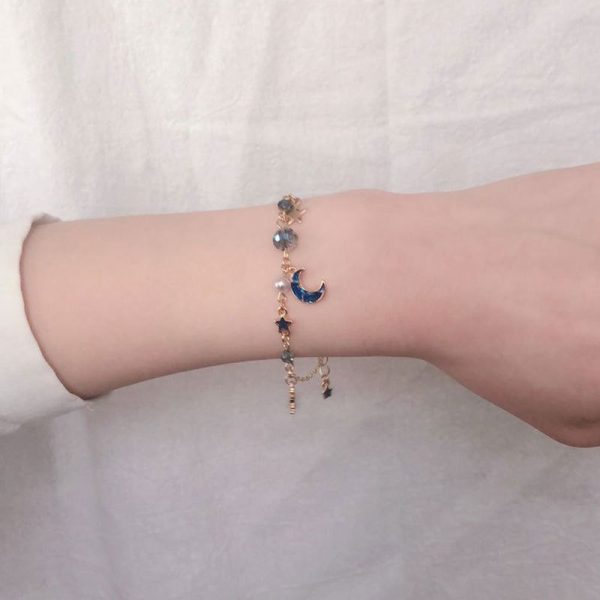 Bracelet breloque chaîne dorée et pendentifs lune et étoile