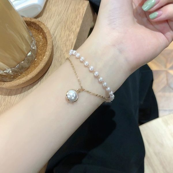 Bracelet breloque chaîne dorée et perles blanches