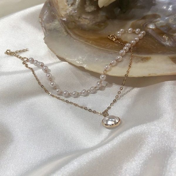 Bracelet breloque chaîne dorée et perles blanches